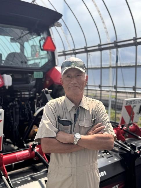 温室内で腕を組む帽子の株式会社中友農産 中村 友平さん